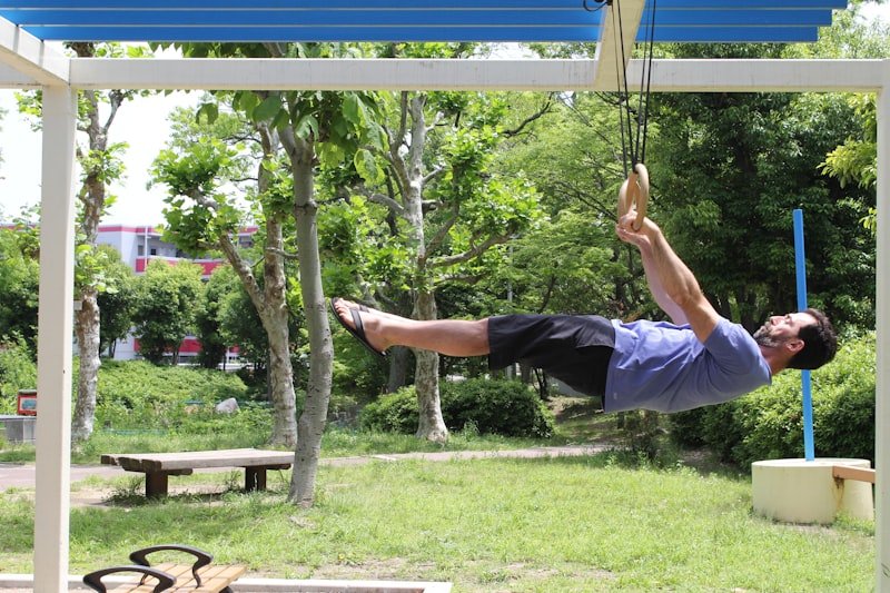 Man exercising on gymnastic rings outdoors